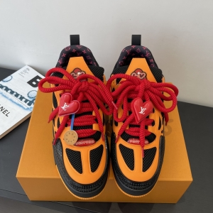 The LV Trainer Sneaker is black and orange with red laces.