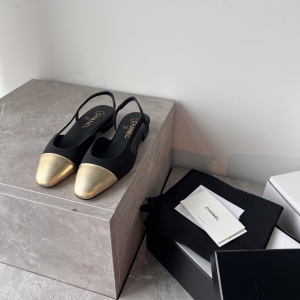 Chanel-style black and gold color-blocked open-back flats